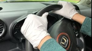 Gloved Hands on Steering Wheel while driving a car